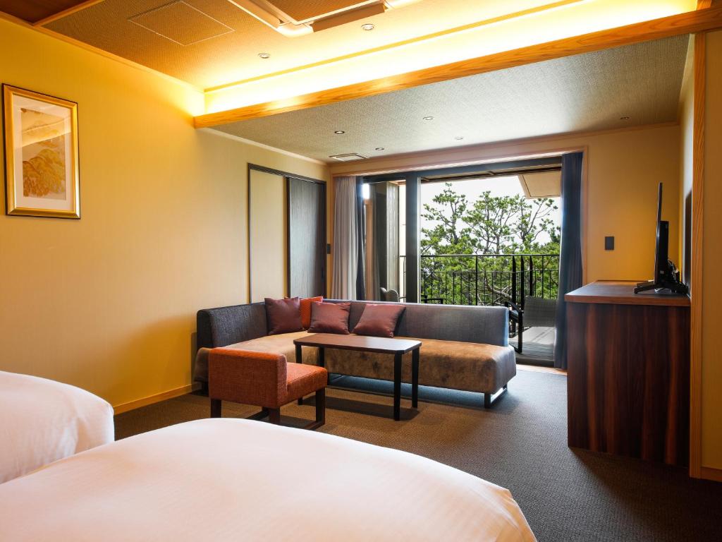une chambre d'hôtel avec un canapé et une table dans l'établissement Awaji Hamarikyu Takumi, à Minamiawaji