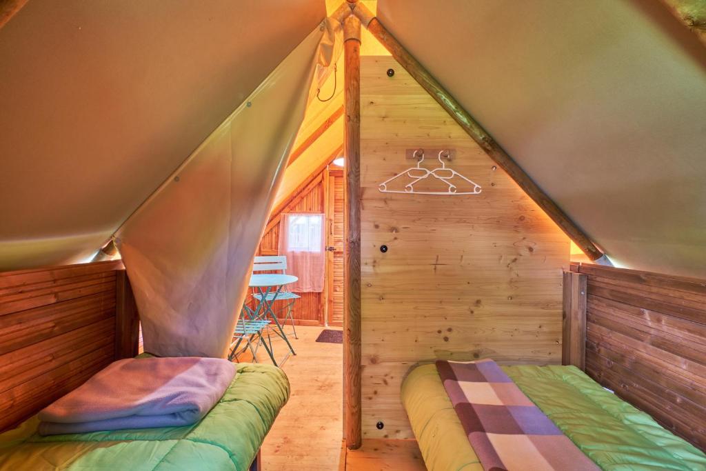 une chambre avec un lit à l'intérieur d'une tente dans l'établissement Caravane Tente 2 places, à Mens