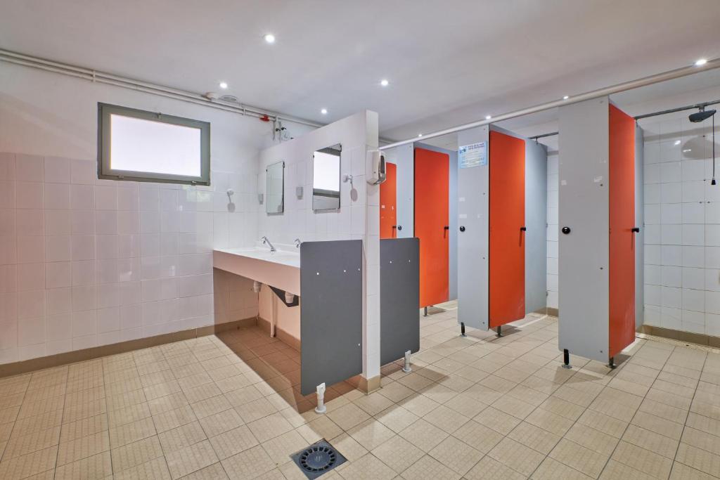 une salle de bain avec un lavabo et quelques cabines dans l'établissement Caravane Tente 2 places, à Mens