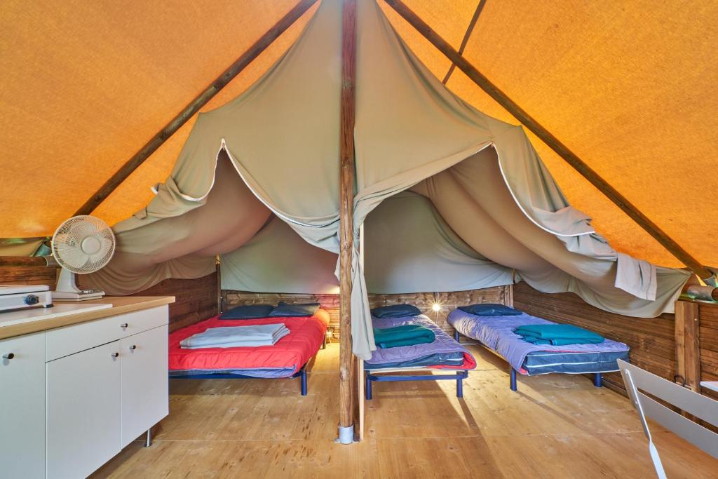 une tente avec 2 lits dans une chambre dans l'établissement Tente 4 personnes, à Mens 21 autres photos
