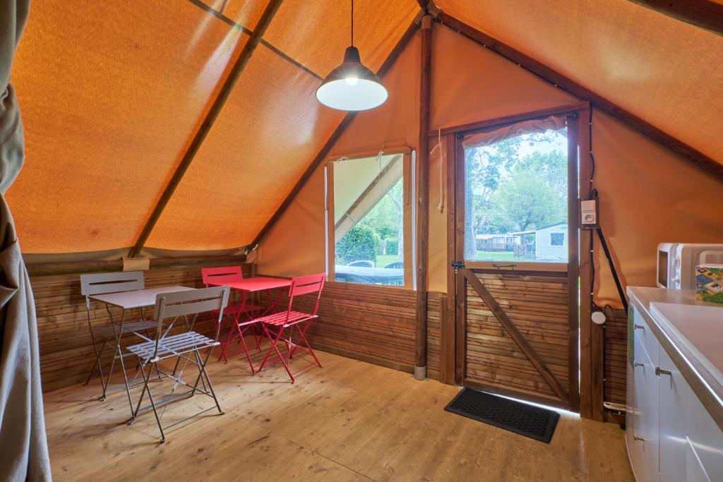 une chambre avec deux chaises et une table dans une maison dans l'établissement Tente 4 personnes, à Mens
