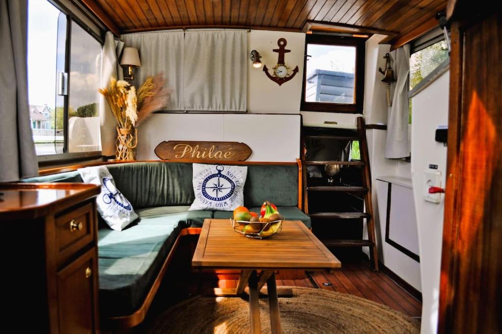 un salon avec un canapé et une table dans l'établissement C'la Vie - Proche Fontainebleau - Bateau, à Nemours