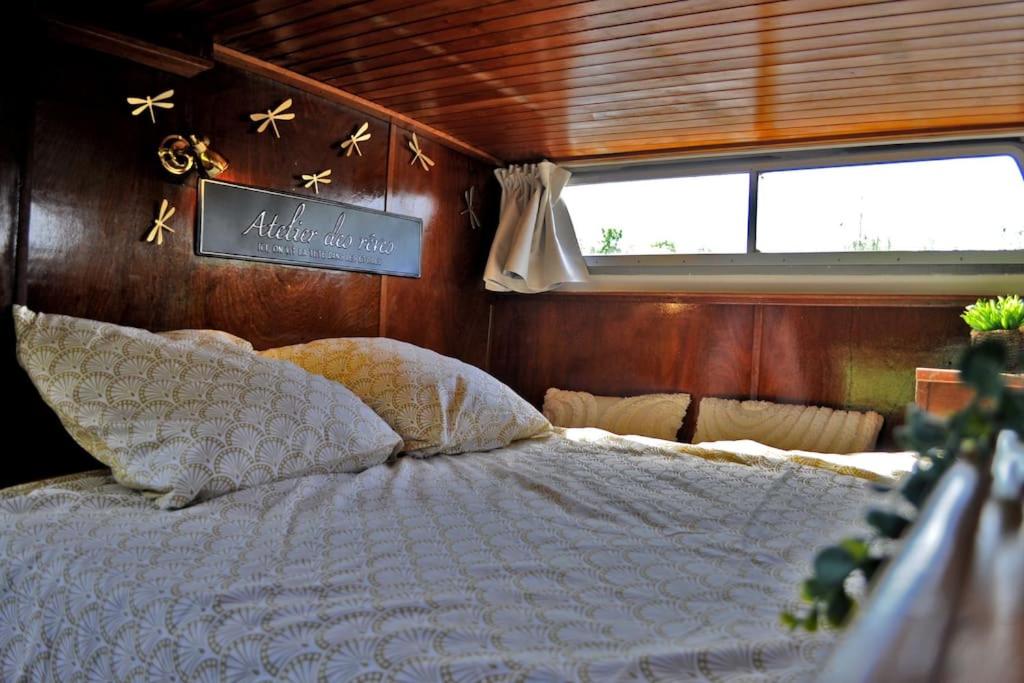 - une chambre avec un lit dans un bateau dans l'établissement C'la Vie - Proche Fontainebleau - Bateau, à Nemours