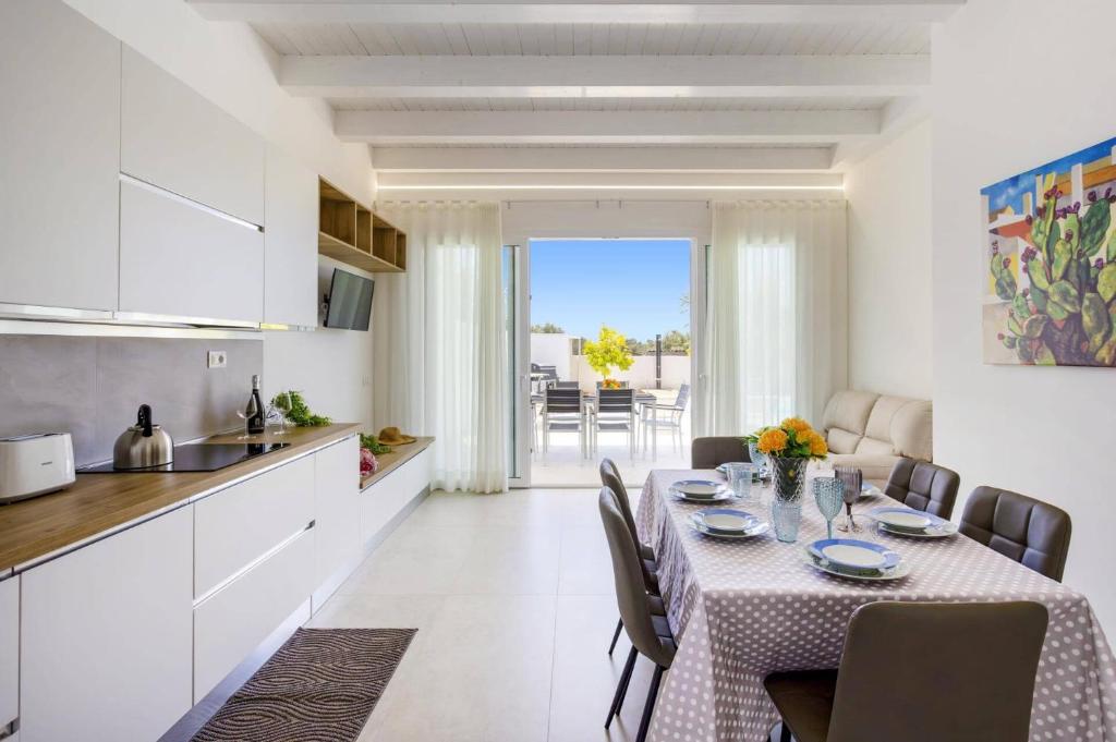 une cuisine et une salle à manger avec une table dans une pièce dans l'établissement Villa Ares by Villa Plus, à Santa Maria Del Focallo