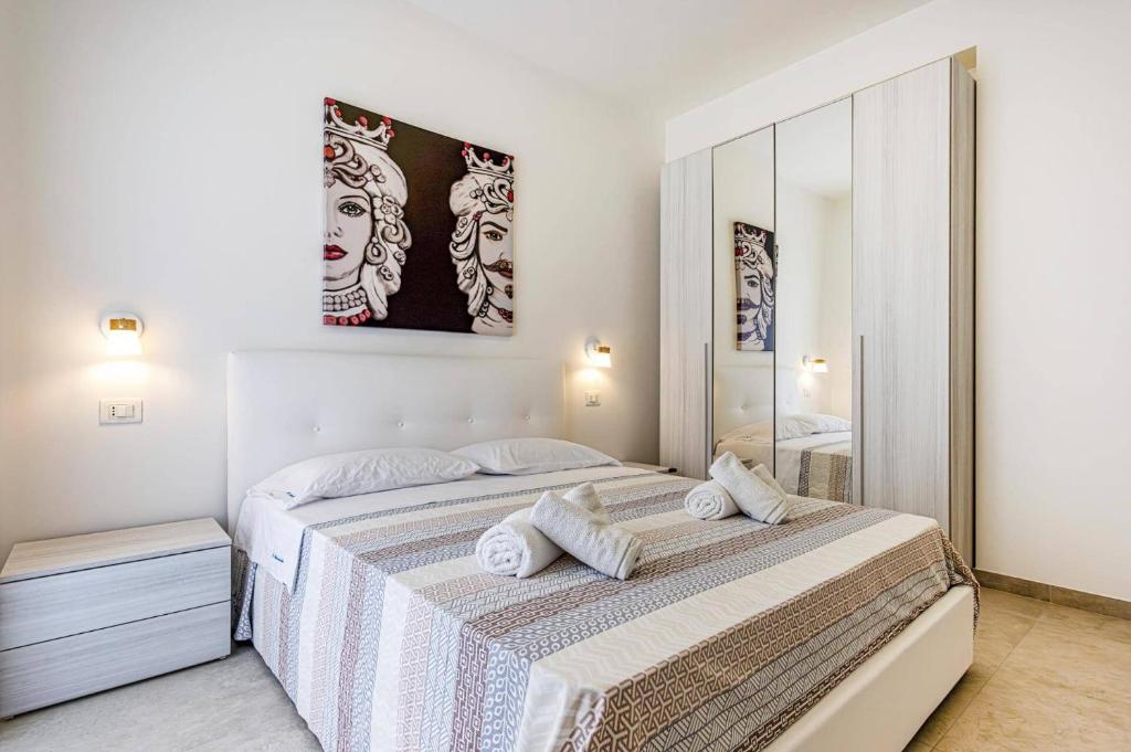 une chambre blanche avec un lit et un miroir dans l'établissement Villa Ares by Villa Plus, à Santa Maria Del Focallo