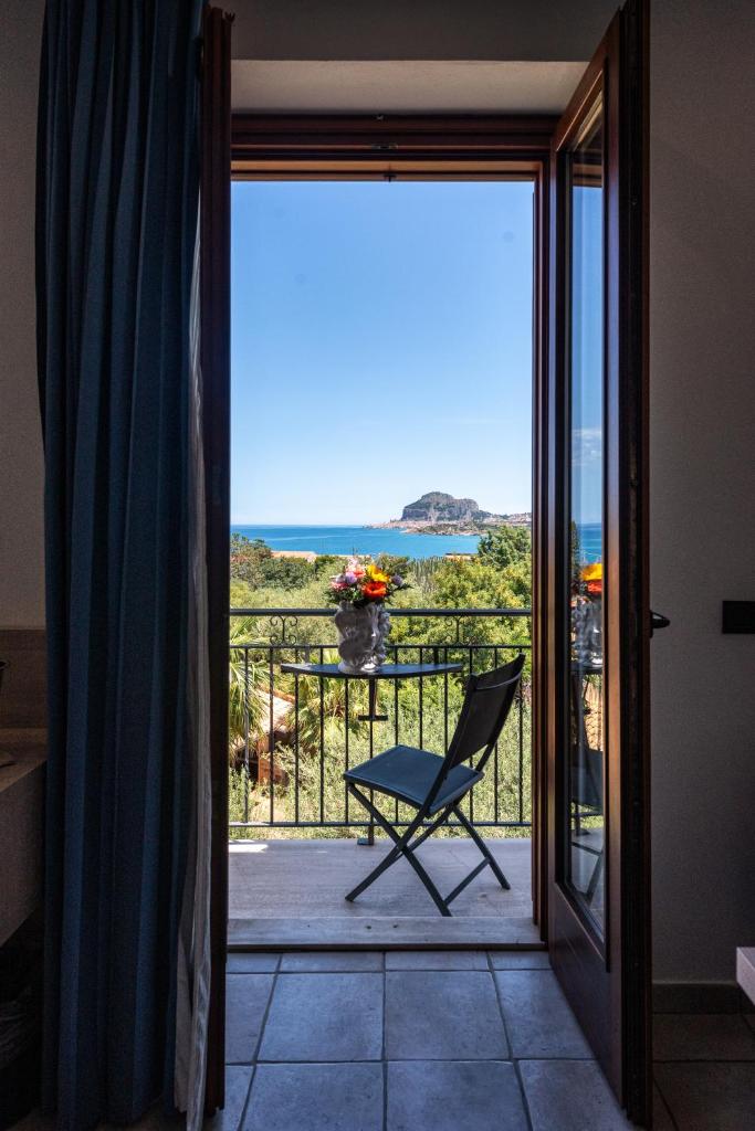 une chaise sur un balcon avec vue sur l'océan dans l'établissement Hotel Baia Del Capitano, à Cefalù