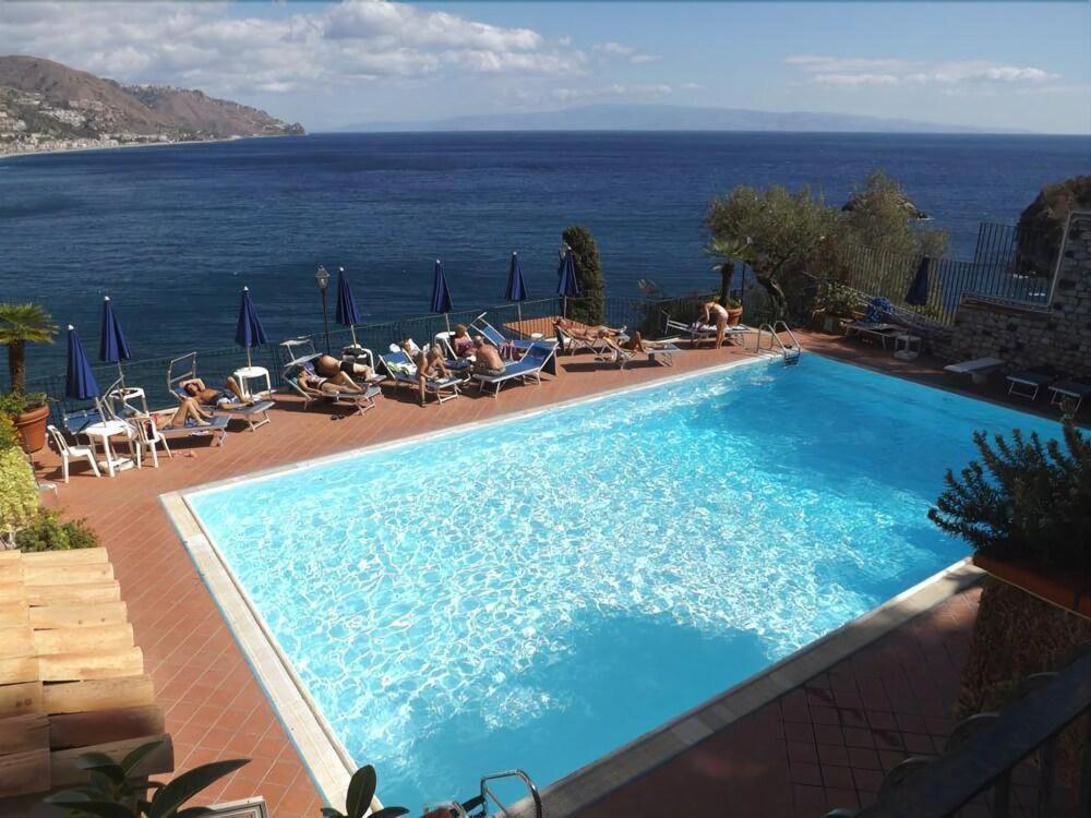 une piscine avec vue sur l'océan dans l'établissement Bay Palace Mazzarò, à Taormine