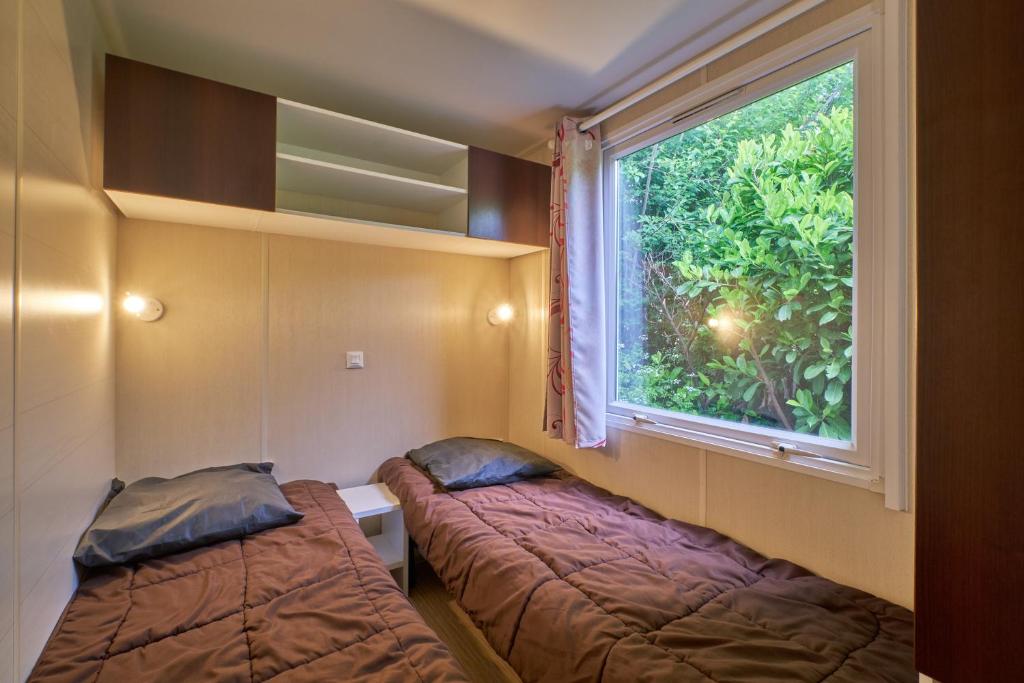 une chambre avec deux lits et une fenêtre dans l'établissement Mobil Home 4 personnes 208, à Mens