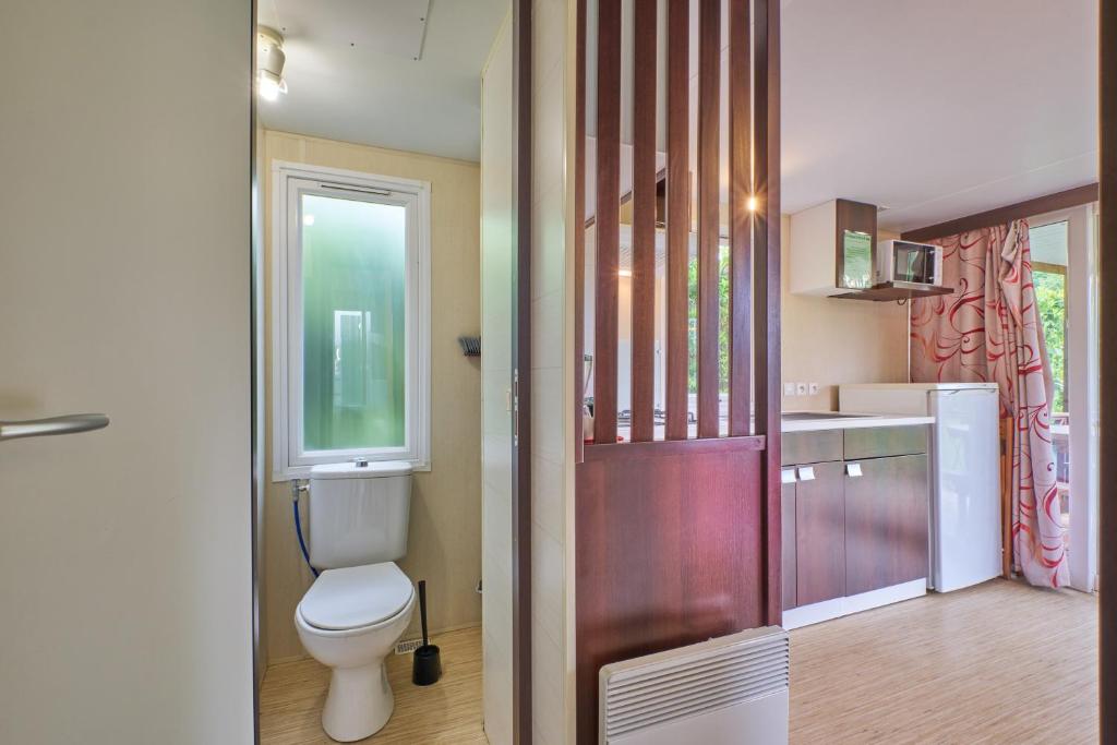 une salle de bain avec toilettes et lavabo dans l'établissement Mobil Home 4 personnes 208, à Mens