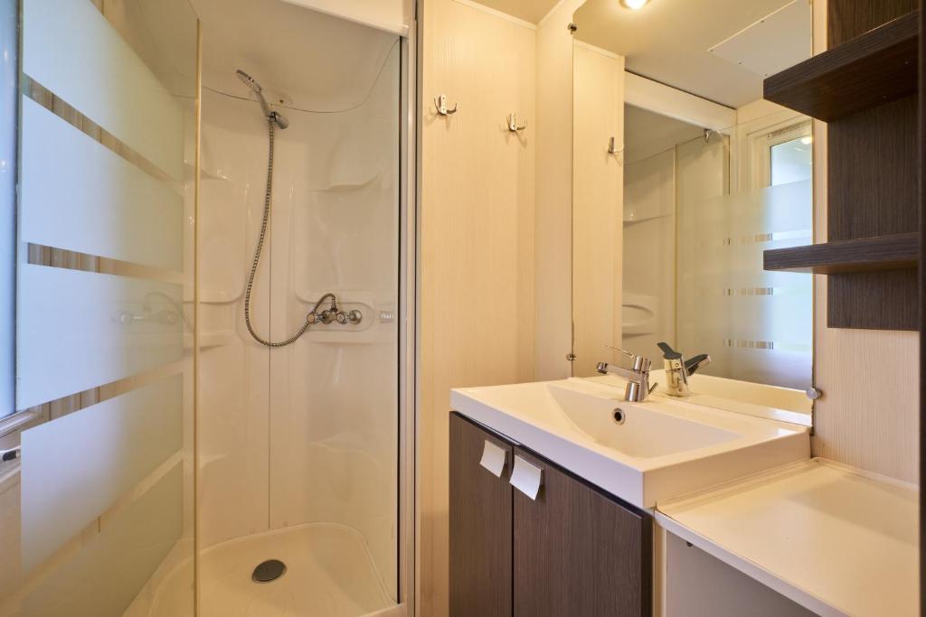 une salle de bain avec un lavabo et une douche dans l'établissement Mobil Home 4 personnes 201, à Mens