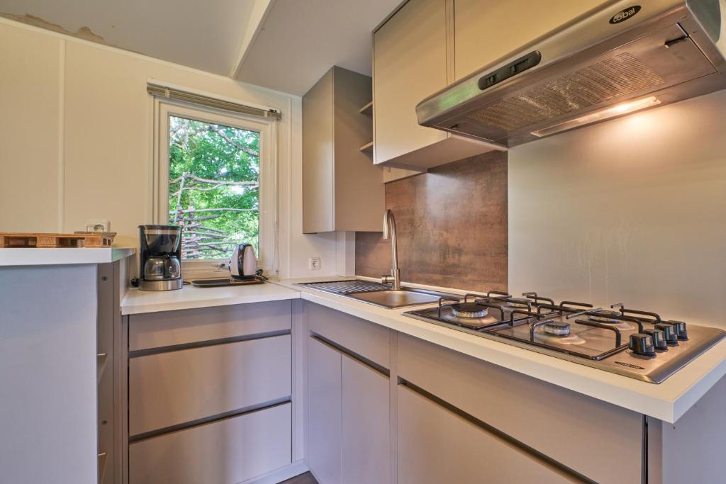 une cuisine avec une cuisinière et un évier dans l'établissement Mobil Home 4 personnes 207, à Mens