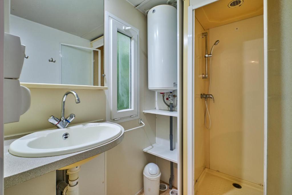 une salle de bain avec un lavabo et une douche dans l'établissement Mobil Home 4 personnes 202, à Mens