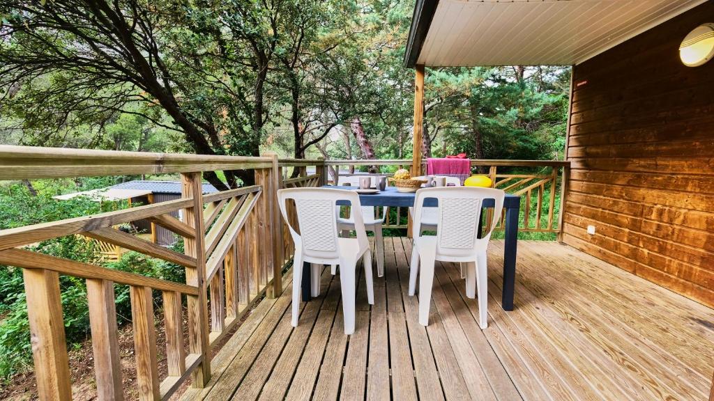 une table et des chaises sur une terrasse en bois dans l'établissement Camping de la Vallée Heureuse, à Orgon