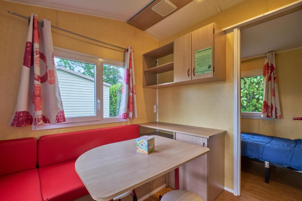 un salon avec un canapé rouge et une table dans l'établissement Mobil Home 5 personnes 210, à Mens
