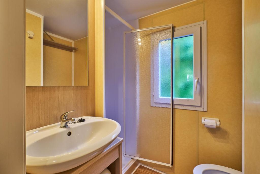 une salle de bain avec un lavabo et une douche dans l'établissement Mobil Home 5 personnes 210, à Mens