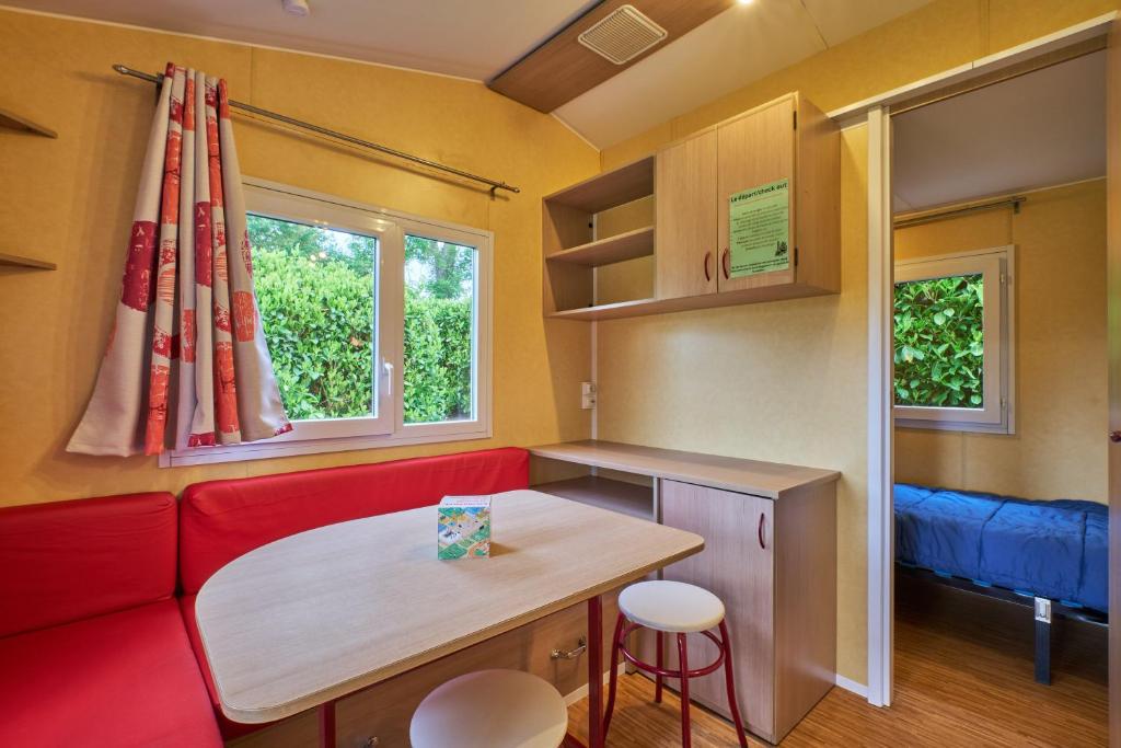 un salon avec un canapé rouge et une table dans l'établissement Mobil Home 5 personnes 209, à Mens