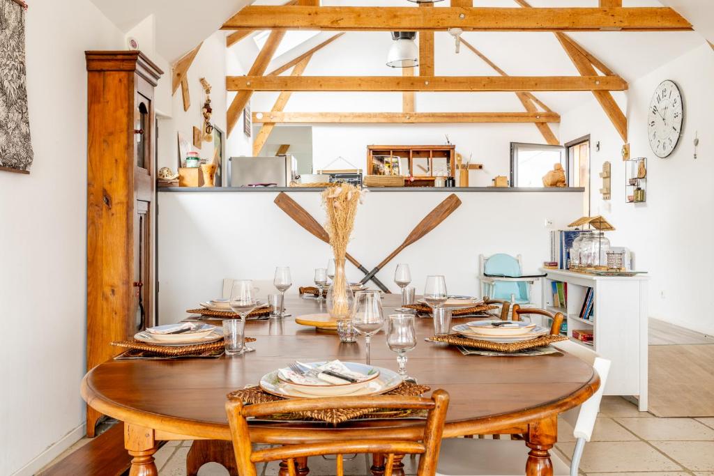 une salle à manger avec une table et des chaises en bois dans l'établissement Gîte Le Jardin d'Eden, à Bovel