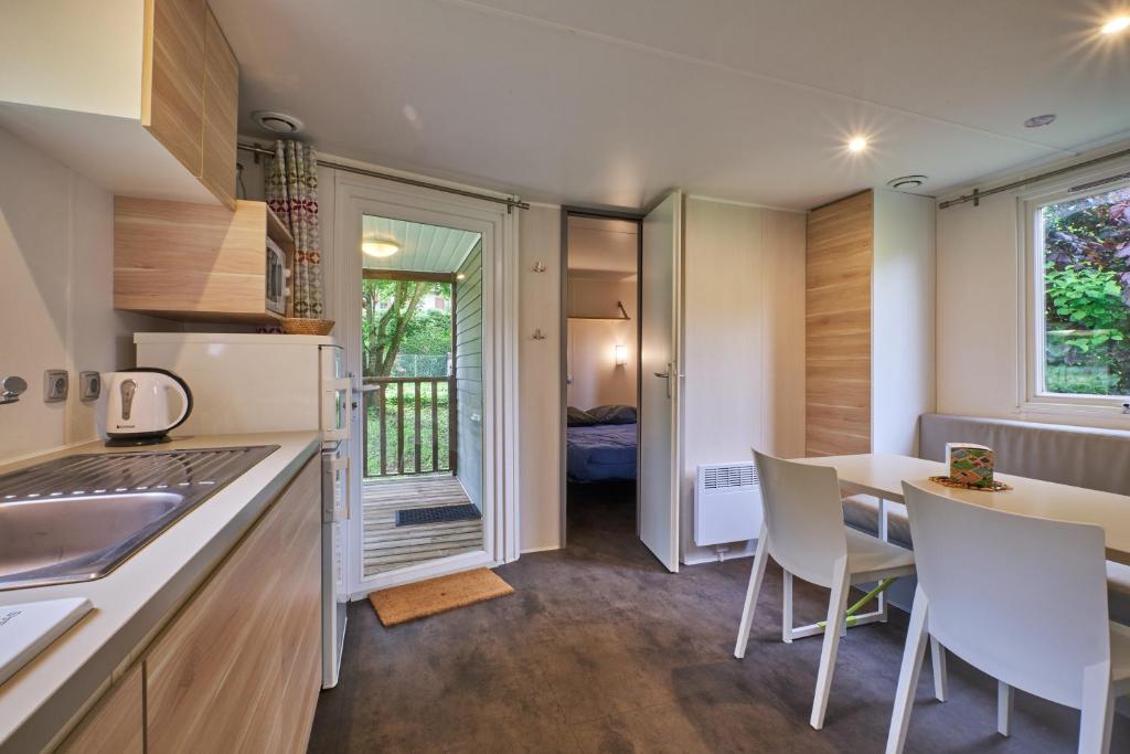 une cuisine et une salle à manger avec une table et des chaises dans l'établissement Mobil Home 4 personnes 204, à Mens