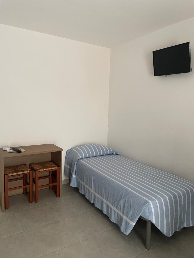 une chambre avec un lit, une table et une télévision dans l'établissement Hotel Ponte, à Vieste