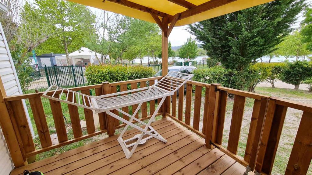 une chaise à bascule blanche assise sur une terrasse en bois dans l'établissement Mobil Home au calme Camping 4 Cadenet, à Cadenet 4 autres photos