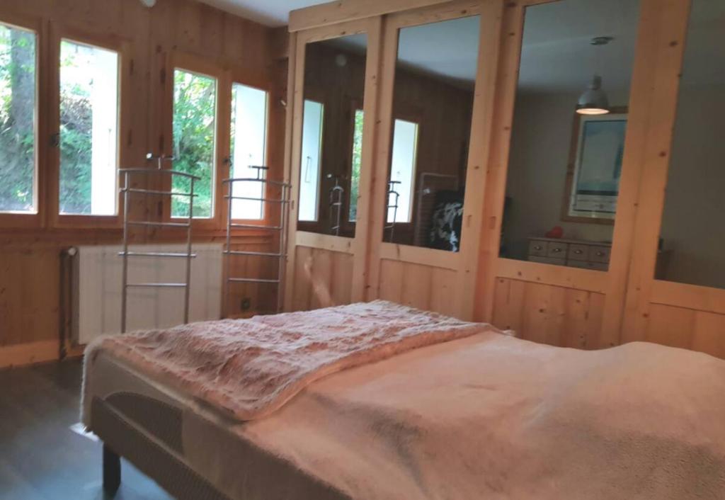 - une chambre avec un lit doté de murs en bois et de fenêtres dans l'établissement A Cordon entre Bois et Nature, à Cordon