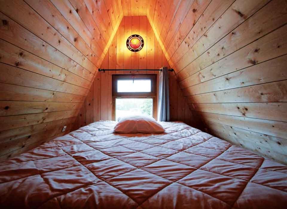 un lit dans une petite pièce avec une fenêtre dans l'établissement Cerza Safari Lodge, à Hermival-les-Vaux