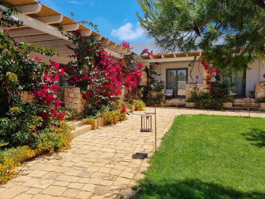 un jardin avec des fleurs roses sur une maison dans l'établissement Masseria Baroni di Montesardo, à Lido Marini