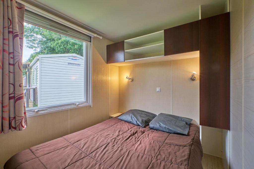 une petite chambre avec un lit et une fenêtre dans l'établissement Mobil Home 4 personnes 208, à Mens 18 autres photos