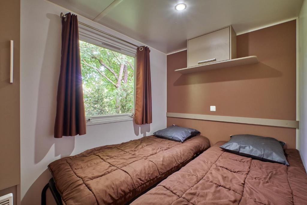une chambre avec deux lits et une fenêtre dans l'établissement Mobil Home 6 personnes 205, à Mens