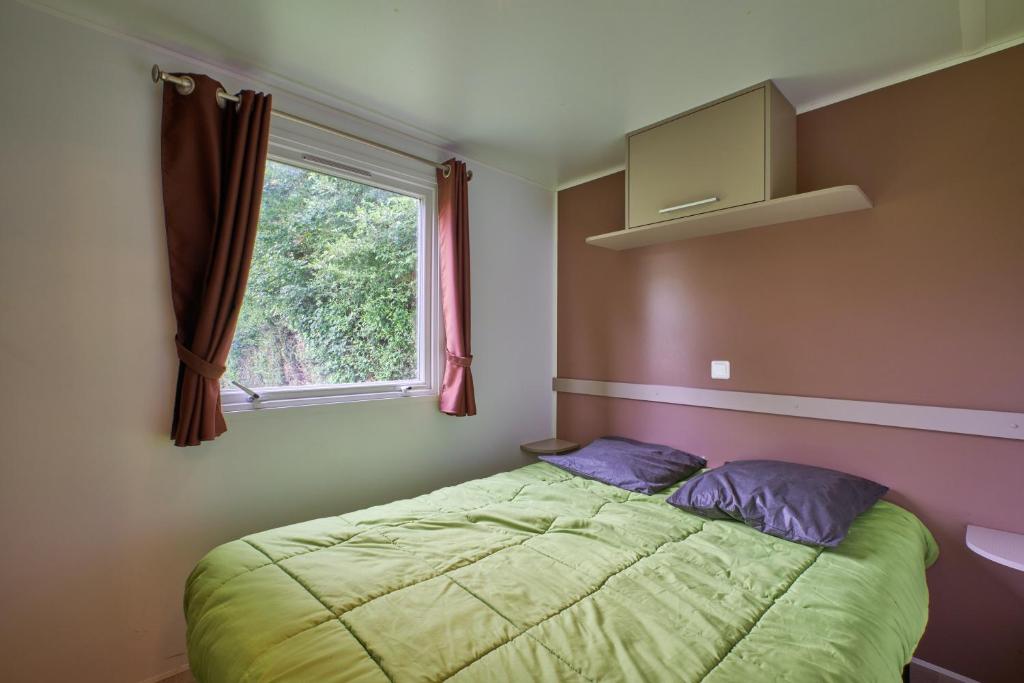 une petite chambre avec un lit et une fenêtre dans l'établissement Mobil Home 6 personnes 205, à Mens 15 autres photos