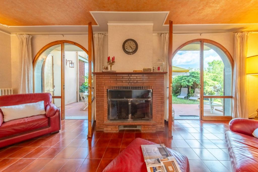 - un salon avec une cheminée et un canapé rouge dans l'établissement Villa di Massotondo, à Rignano sullʼArno 48 autres photos