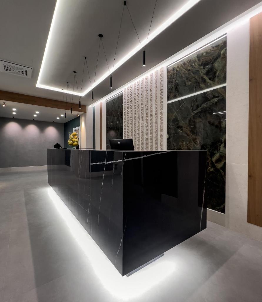 un hall d'accueil avec un comptoir de réception noir avec des lumières dans l'établissement Maiorano Boutique Hotel, à Manfredonia 21 autres photos