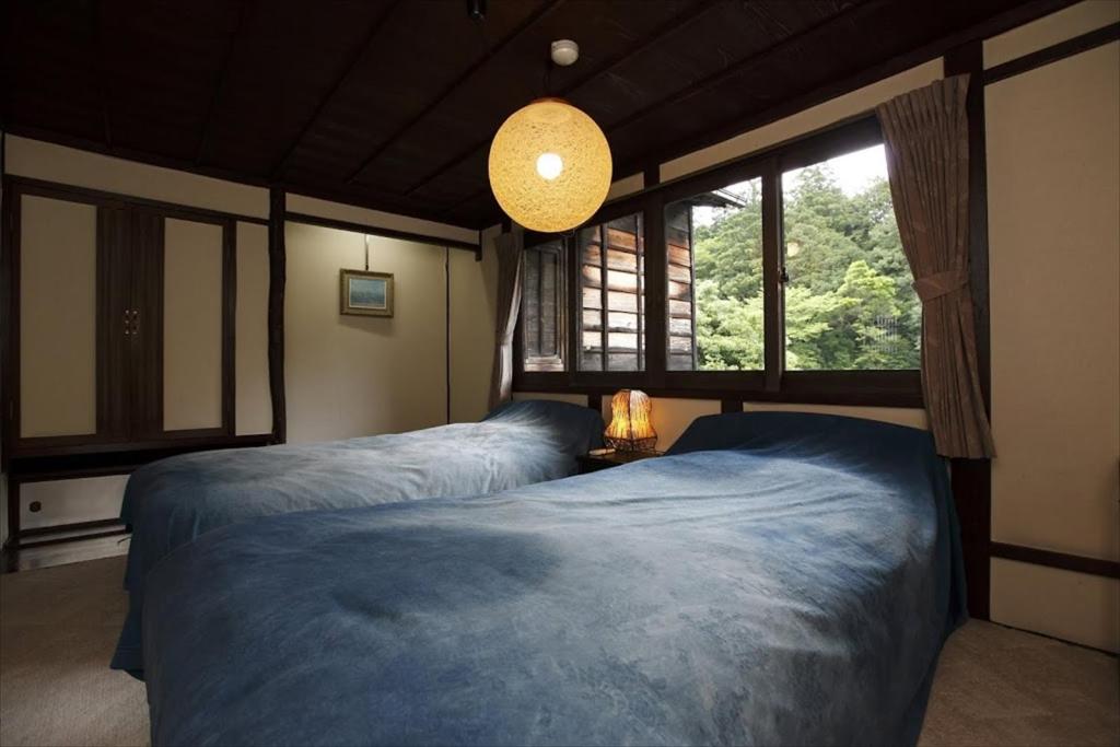une chambre avec deux lits et une grande fenêtre dans l'établissement Hazuki, à Ono