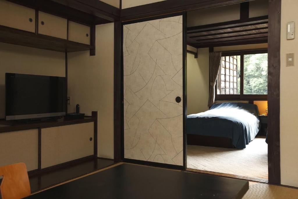 une chambre avec un lit et une porte coulissante en verre dans l'établissement Hazuki, à Ono