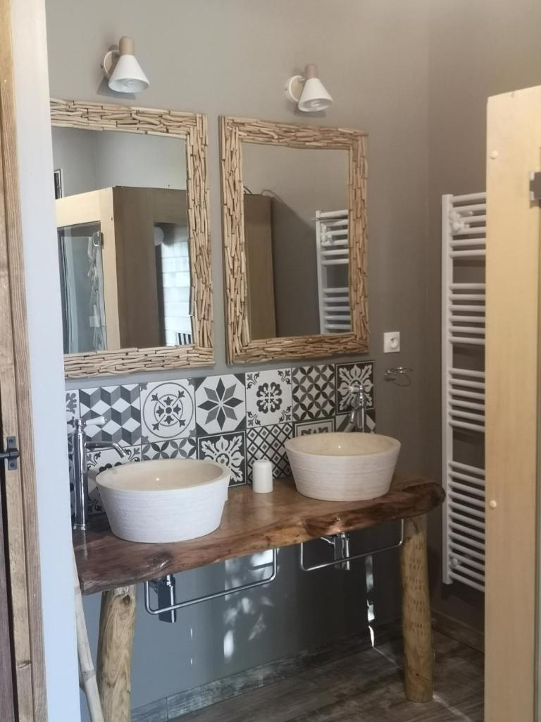 deux lavabos dans une salle de bain avec deux miroirs dans l'établissement La Roulotte de la Trigalle, à Valognes