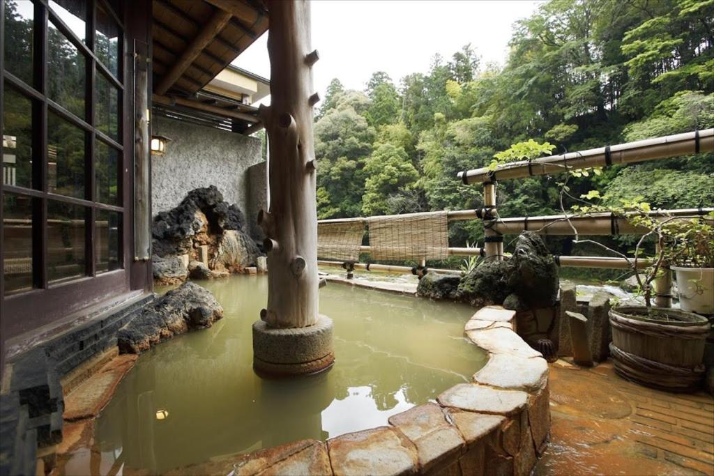 une piscine d'eau en face d'un bâtiment dans l'établissement Hazu Bekkan, à Ono