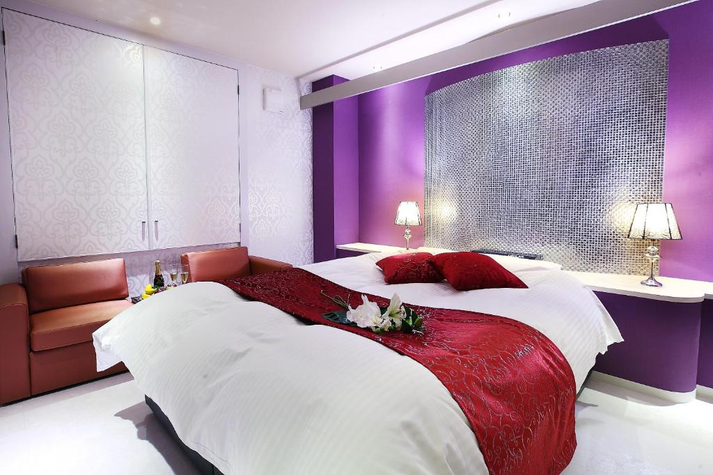 une chambre avec un grand lit aux murs violets dans l'établissement Hotel L'eclair (Adult Only), à Fukuyama 22 autres photos