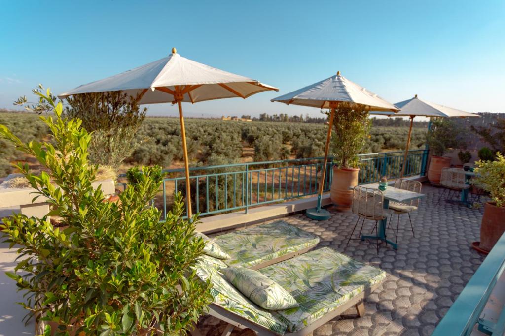 - une terrasse avec des parasols, une table et des chaises dans l'établissement Riad Bab Ahmar, à Marrakech