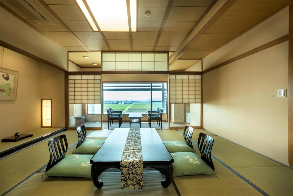 une salle à manger avec une longue table et des chaises dans l'établissement Grandia Housen, à Awara