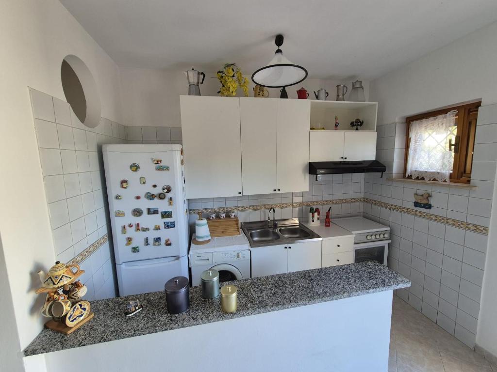 une petite cuisine avec un réfrigérateur et un évier dans l'établissement Villa Sabaudia, à Sabaudia