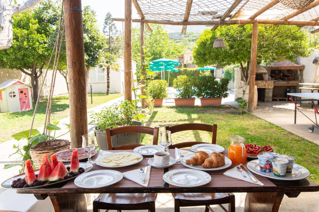 une table en bois avec des assiettes de nourriture dessus dans l'établissement Residence Villa Tina, à Ischia