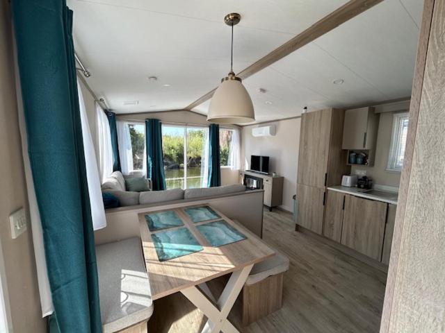 un salon avec une table et une cuisine dans l'établissement mobil home climatisé, à Grimaud