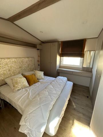 une chambre avec un grand lit avec des draps et des oreillers blancs dans l'établissement mobil home climatisé, à Grimaud 7 autres photos