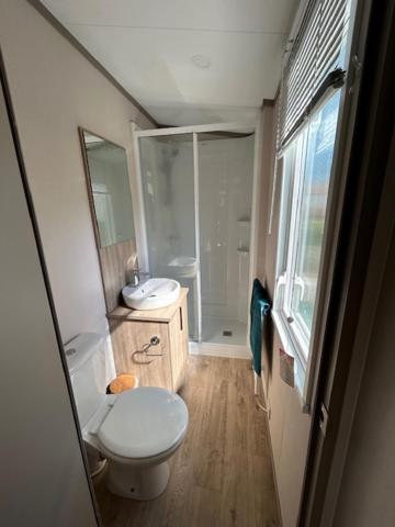 une petite salle de bain avec toilettes et lavabo dans l'établissement mobil home climatisé, à Grimaud