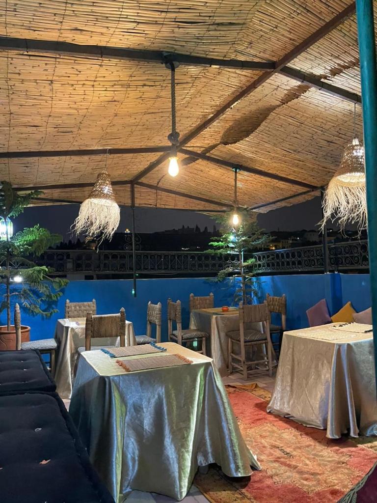 une salle à manger avec des tables, des chaises et des lumières dans l'établissement Riad Blue Oasis, à Fès