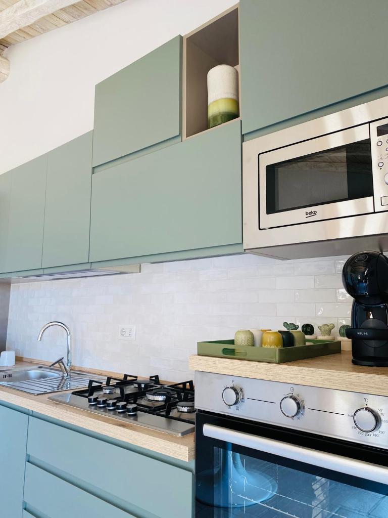 une cuisine avec une cuisinière et un micro-ondes dans l'établissement Villa Case Vecchie, à La Murta 16 autres photos