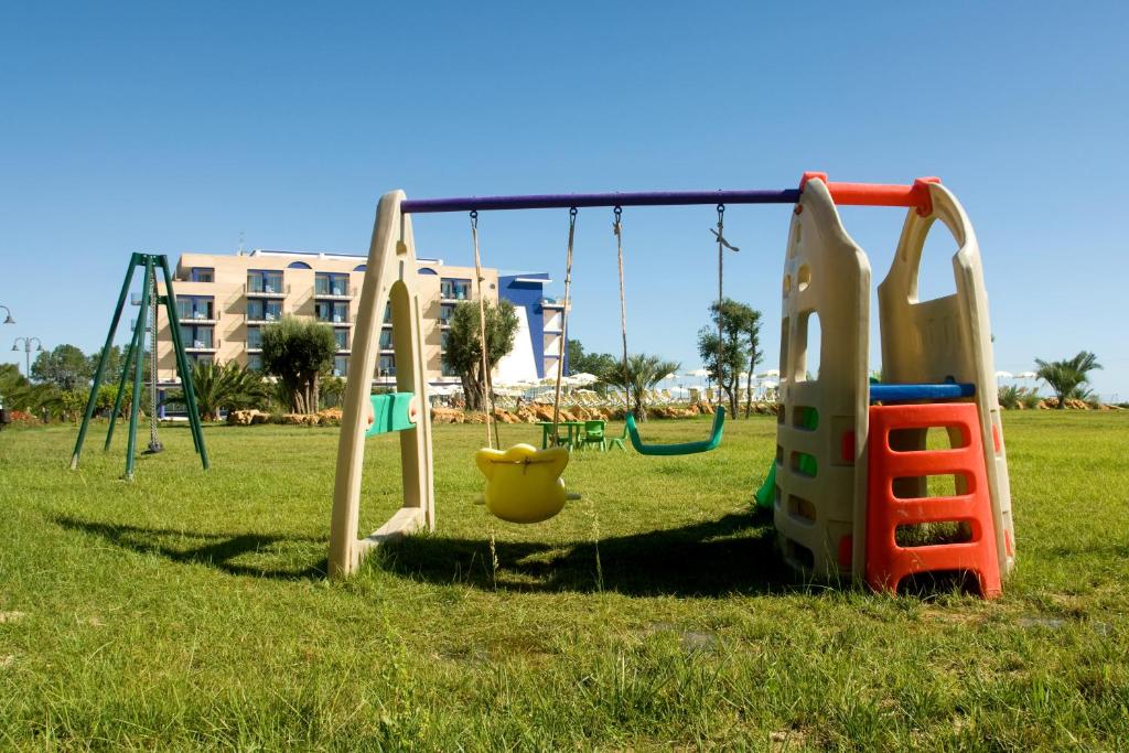 une aire de jeux dans un parc avec une balançoire dans l'établissement Roses Hotel, à Roseto degli Abruzzi