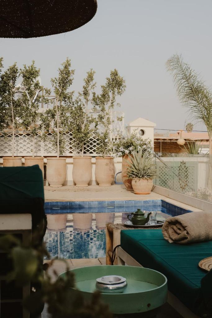 d'une terrasse avec des plantes en pot et une table. dans l'établissement Riad Dar Blanche & Spa, à Marrakech