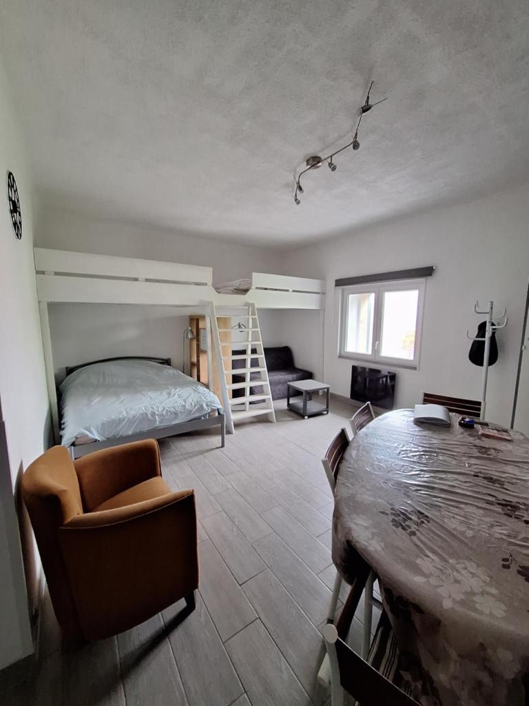 une chambre avec un lit superposé et une table dans l'établissement Grand Studio rénové, tout confort, belles prestations - Résidence du Bois de l'Ours, aux Rousses