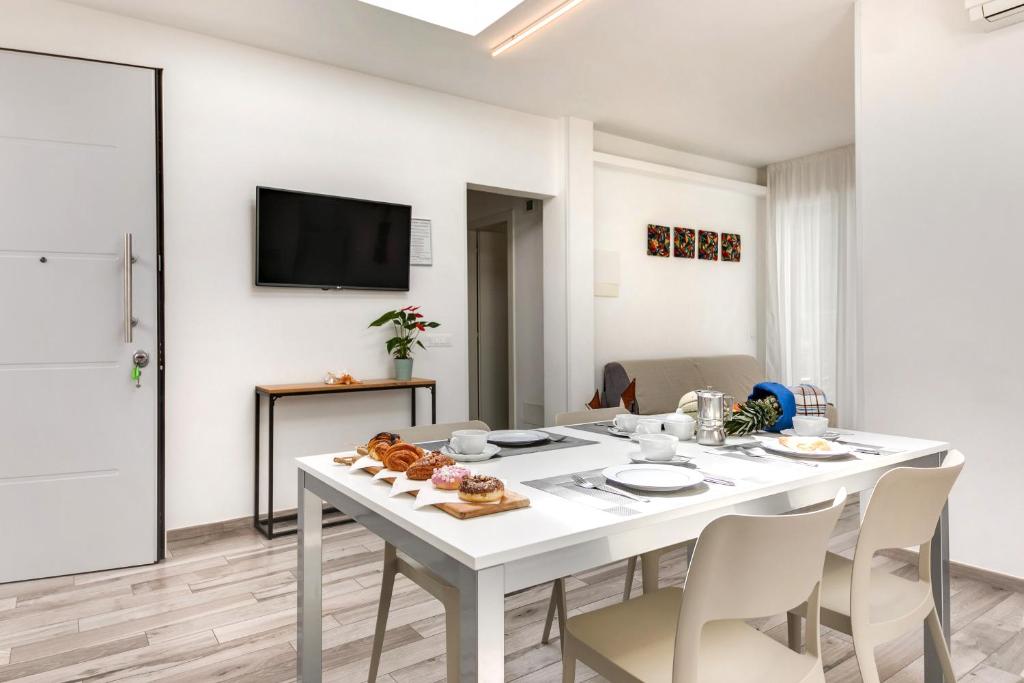 une salle à manger blanche avec une table et des chaises blanches dans l'établissement Residence Diffuso Arcobaleno, à Gabicce Mare